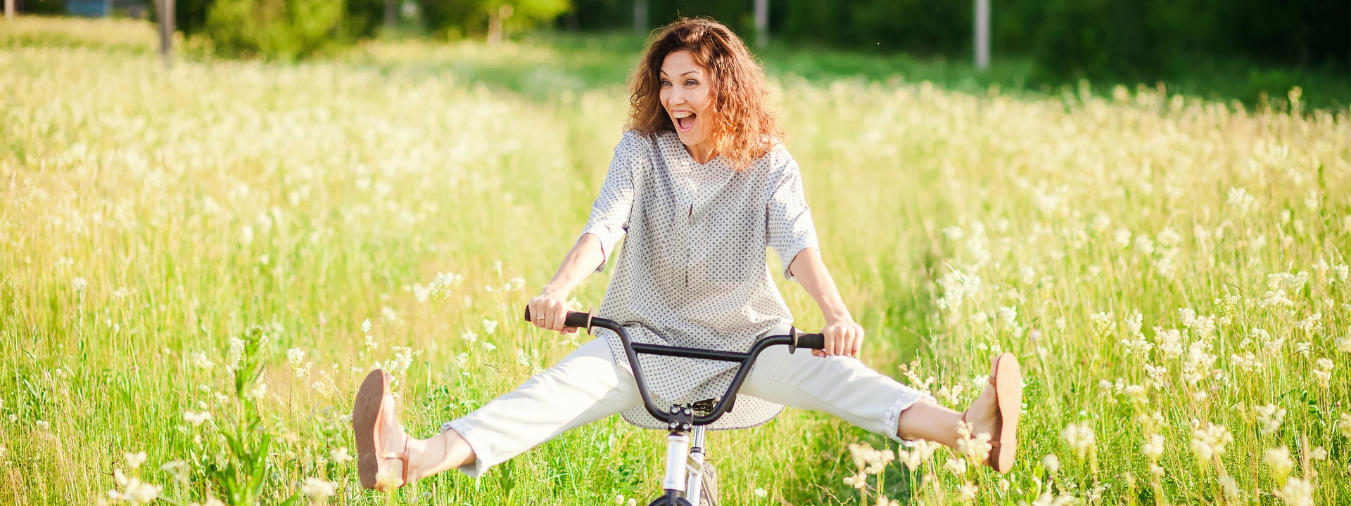 headerbild, persönliche dienstleister:innen, frau am rad, wiese