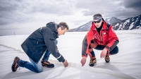 Zwei Menschen bei der Arbeit auf einer Piste