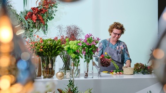 Fröhliche Frau arangiert Blumen