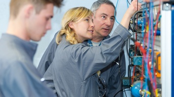 Lehrlinge Elektrik mit Lehrmeister Objekt inspizierend