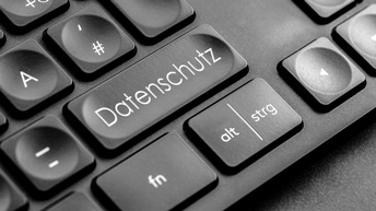 Detailansicht einer schwarzen Computertastatur, im Fokus eine Taste mit weißer Aufschrift Datenschutz