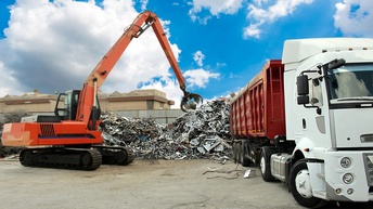 Kran beladet einen LKW mit Metallschrott, Konzept Recycling