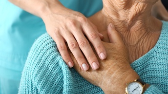 Detailansicht Hand einer Person, die andere Hand einer älteren Person ergreift