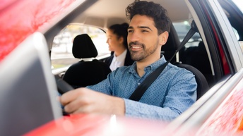 Lächelnde Person lenkt rotes Autos