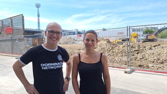 Christian Hetterich, Neo-Gastronom der „Annemarie“ und Head of Dornbach Networks, und Martina Pfluger werfen einen gemeinsamen Blick auf den Baufortschritt des neuen WSC-Stadions.