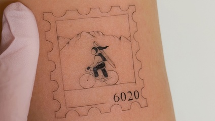 Das typische Briefmarken-Motiv mit der Radlerin mit Ski auf dem Rücken. 