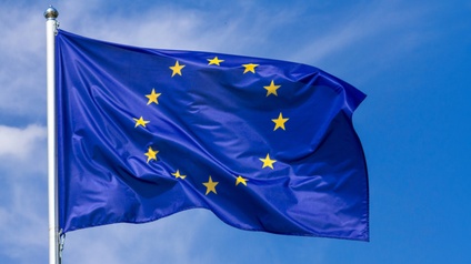 Flagge der Europäischen Union im Wind wehend, im Hintergrund blauer Himmel