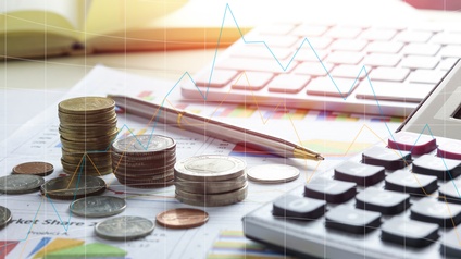 Nahaufnahme von einem Papier mit Diagrammen und Berechnungen, einem Taschenrechner, einem Kugelschreiber sowie gestapelten Münzen. Über das Bild ist eine Grafik mit einer Statistik gelegt