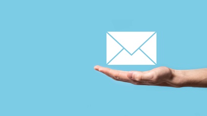 Eine offene Hand über der ein Briefumschlagsymbol für E-Mails steht
