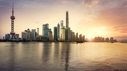 Stadtansicht Shanghai: Wolkenkratzer am Wasser gelegen im Sonnenuntergang