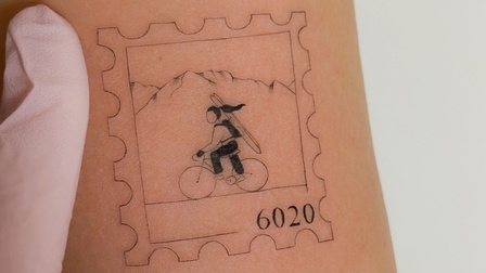Das typische Briefmarken-Motiv mit der Radlerin mit Ski auf dem Rücken. 