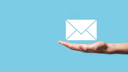 Eine offene Hand über der ein Briefumschlagsymbol für E-Mails steht