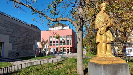 Bildungshaus Kardinal König von außen mit Denkmal im Vordergrund