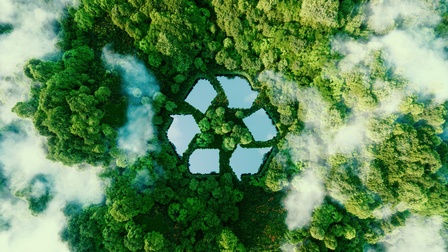 Vogelperspektive eine Laubwaldes durchbrochen von Wolken, mittig kleine Gewässer, die Symbolik eines Recyclingzeichens bilden