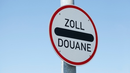 Weißes Schild mit rotem Rand und Aufschrift Zoll sowie Douane