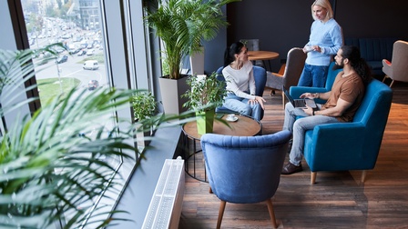 Personen sitzen in einem floralen und bequemen Besprechungsraum