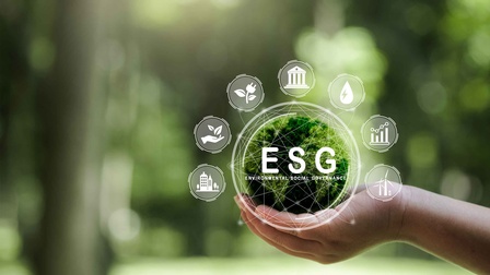 Eine Menschenhand hält einen grüne Kugel mit dem Schriftzug ESG für Environmental, Social und Governance