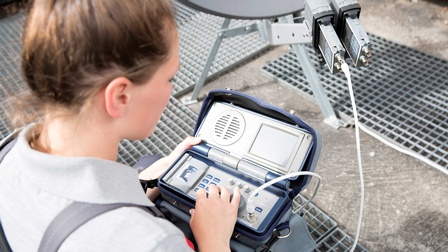 Junge Frau arbeitet an einem Messgerät für eine Satellitenantenne