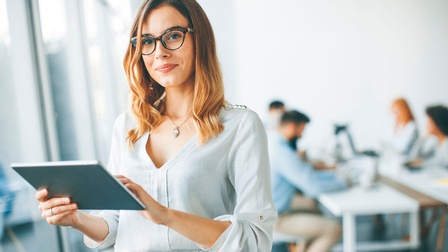 Eine junge Frau mit Tablet in der Hand