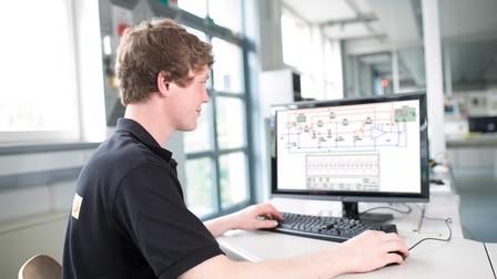 Ein Elektrotechniker bei der Programmierung einer speicherprogrammierbaren Steuerung 