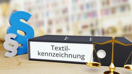 Mappe mit Aufschrift Textilkennzeichnung und Paragraphen-Symbol