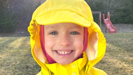 Kind in gelbem Regenmantel