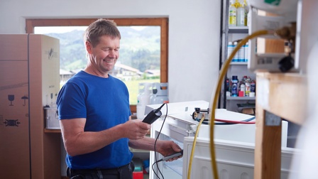 Ein Mann misst den elektrischen Kontakt an einer Kühlschranktür