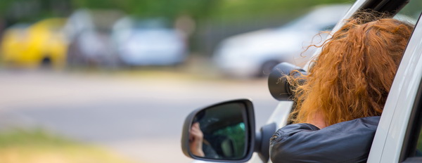 Frau schaut aus Autofenster