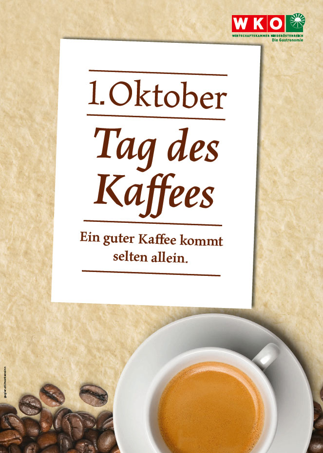 Plakat mit dem Text 1. Oktober Tag des Kaffees und eine volle Kaffeetasse liegen auf kaffebraunem Papier.