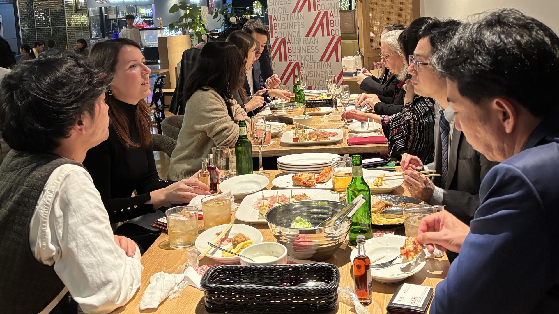 Menschen an einem langen Tisch beim Essen