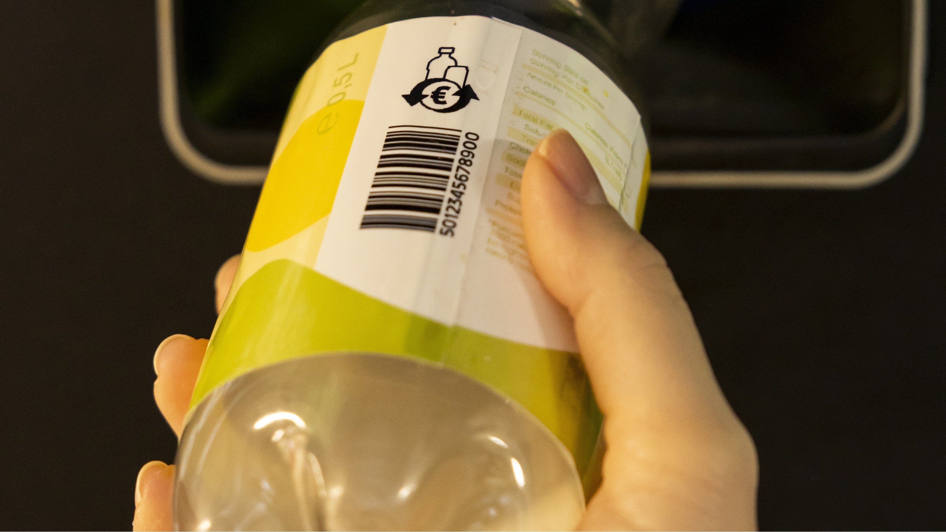 Plastik-Getränkeflasche mit Pfand-Logo wird in Rückgabe-Automat eingeführt