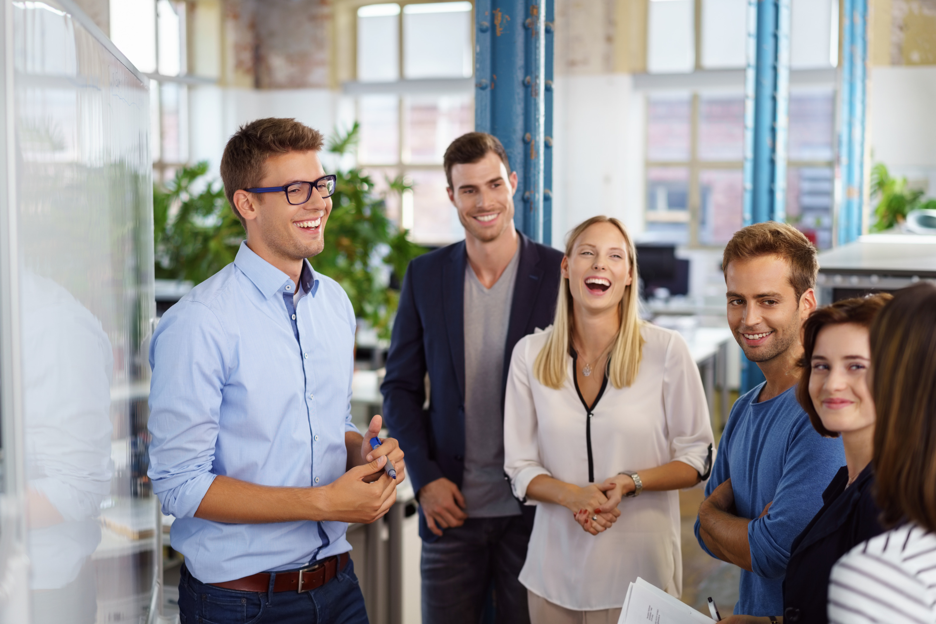 Lachende Personen in einer Besprechung im Büro