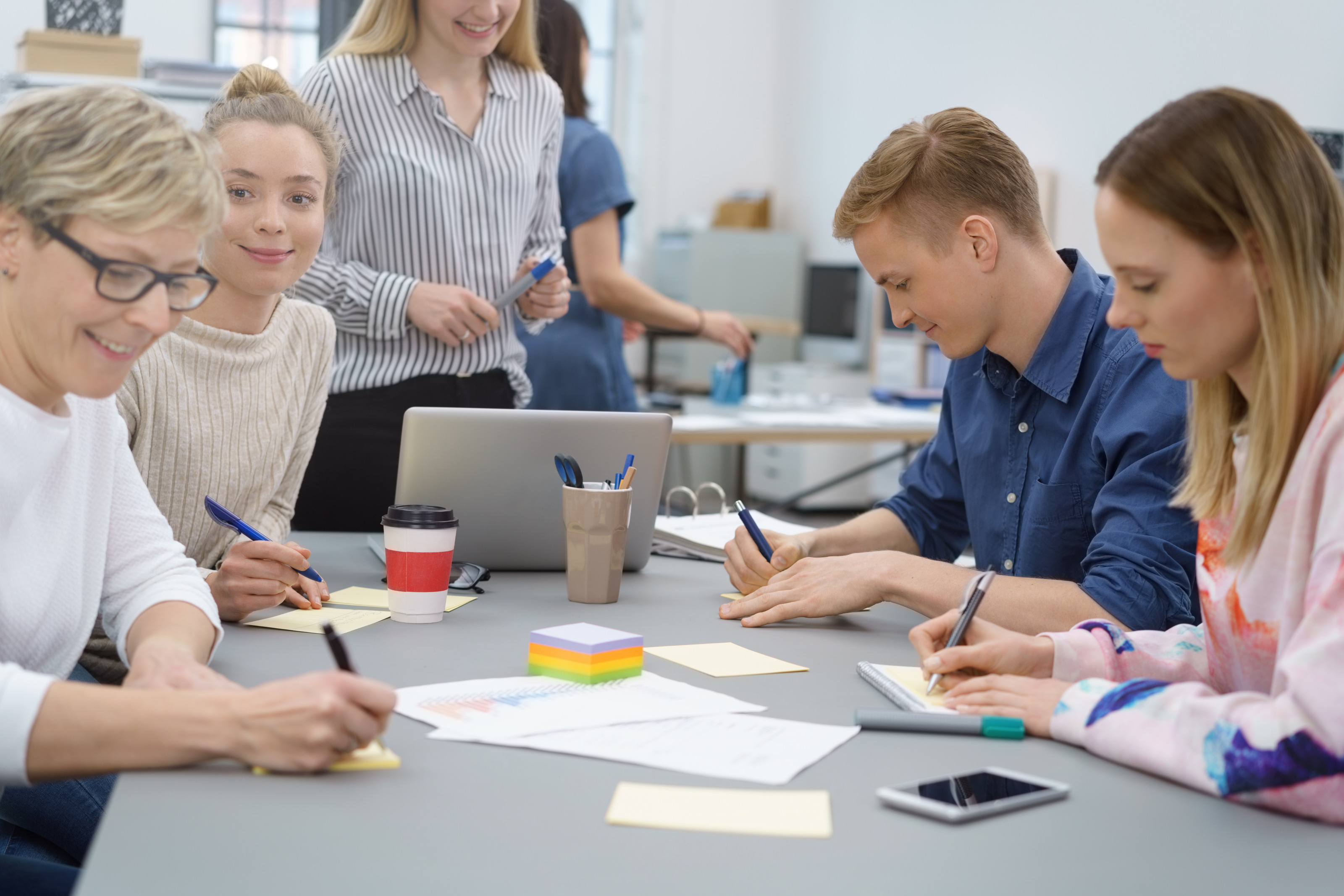 Brainstorming eines Teams mit Notizzetteln an einem Besprechungstisch