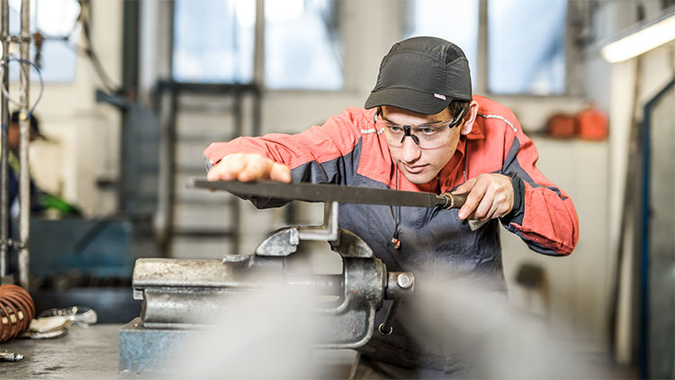 Lehrling der Glasverfahrenstechnik in der Werkstatt bei der Arbeit