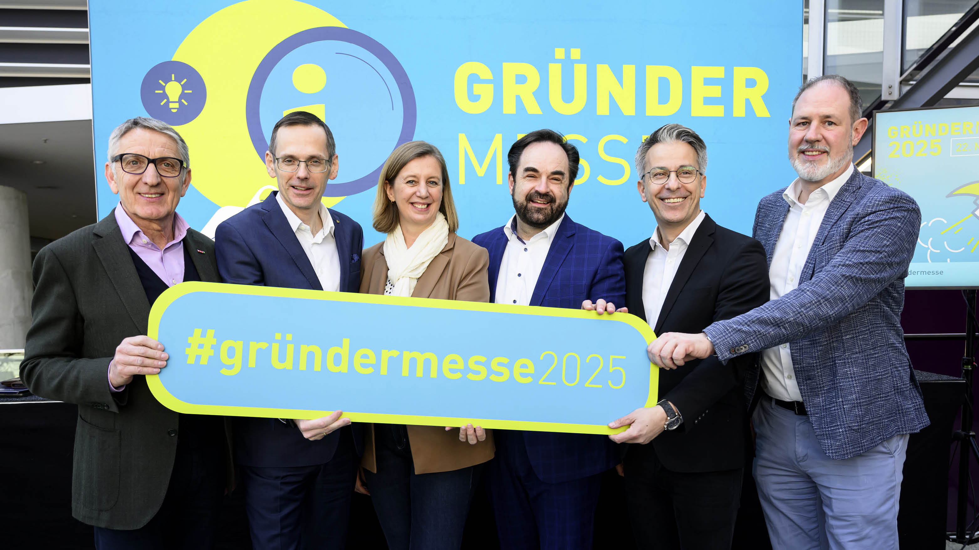 Laden mit einem Schild ein zur Gründermesse 2025 (v.l.): Josef Herk, Oliver Kröpfl, Barbara Eibinger-Miedl, Armin Egger, Kurt Hohensinner und Helmut Sechser.