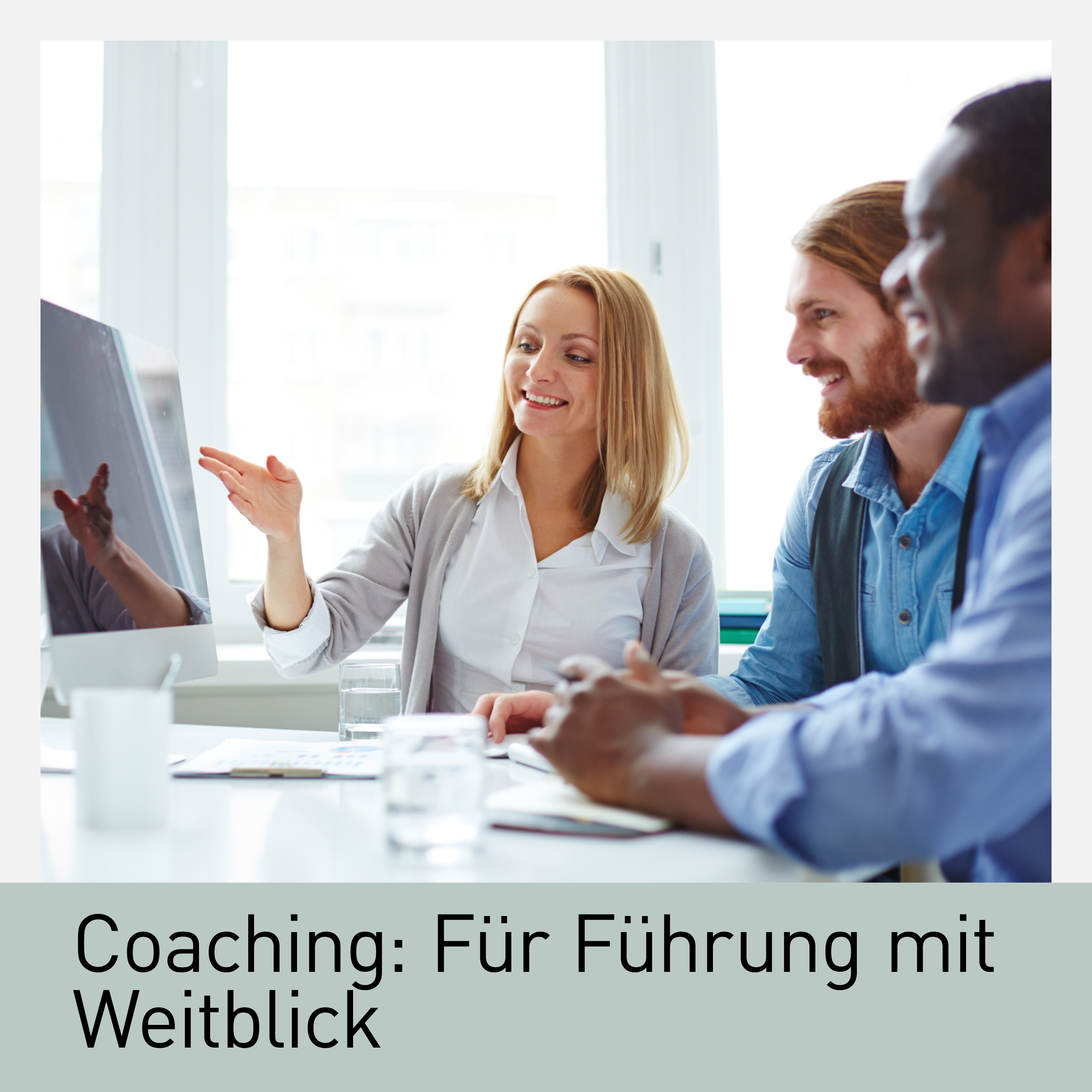 Drei Personen in einem modernen Büro bei einem Coaching-Gespräch. Eine Frau zeigt lächelnd auf den Bildschirm, während zwei Kollegen aufmerksam zuhören. Das Coaching fördert Agilität und Führungskompetenz durch gemeinsame Reflexion und Zusammenarbeit.