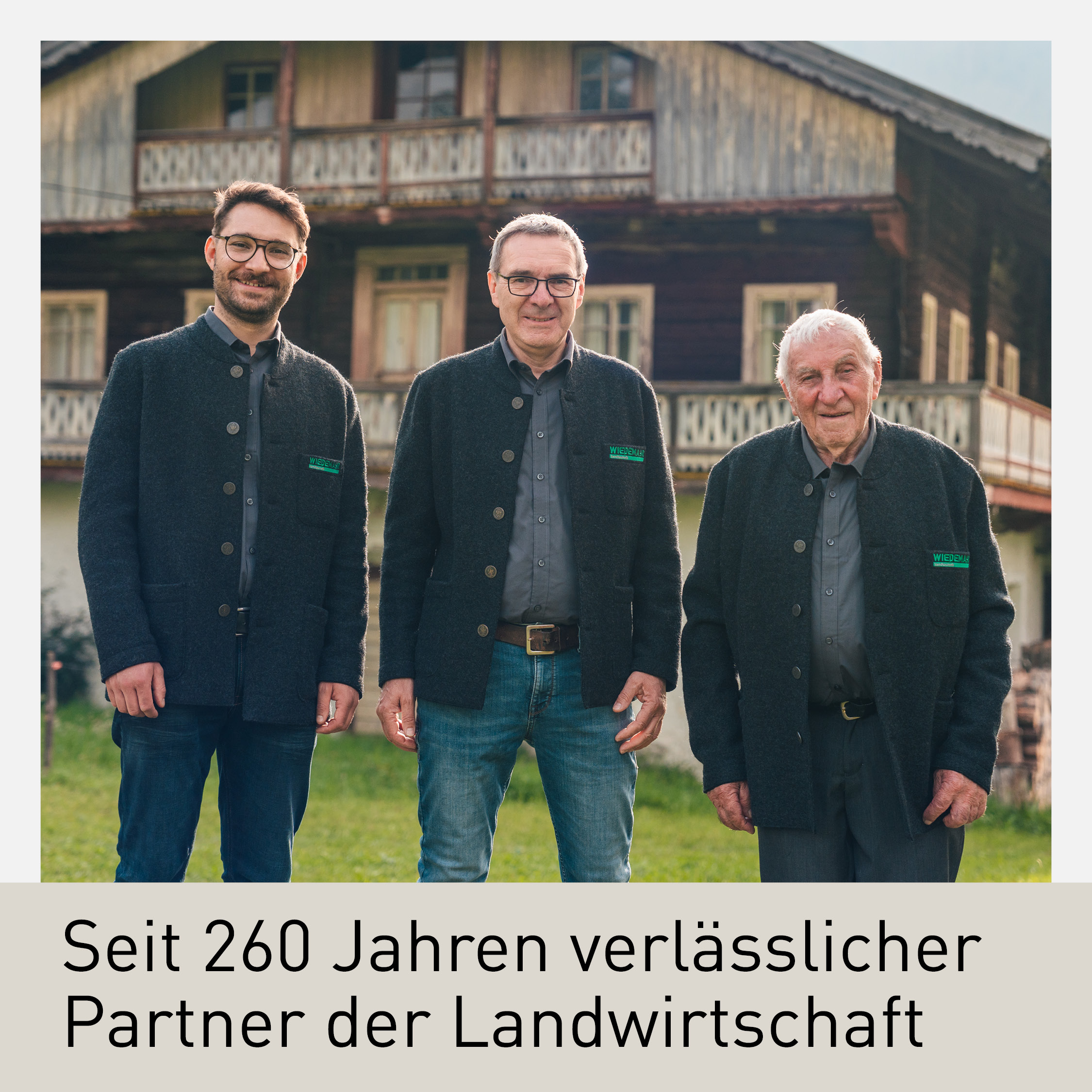 Familienbetrieb Wiedemayr: Drei Generationen vor einem traditionellen Bauernhaus, symbolisieren 260 Jahre Erfolg in der Landtechnik und Landwirtschaft.