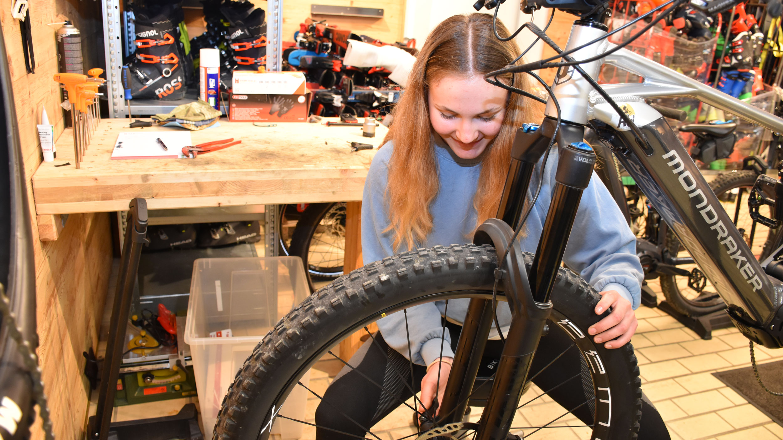 Sportgerätefachkraft-Lehrling Emma bei der Reparatur eines Bikes.