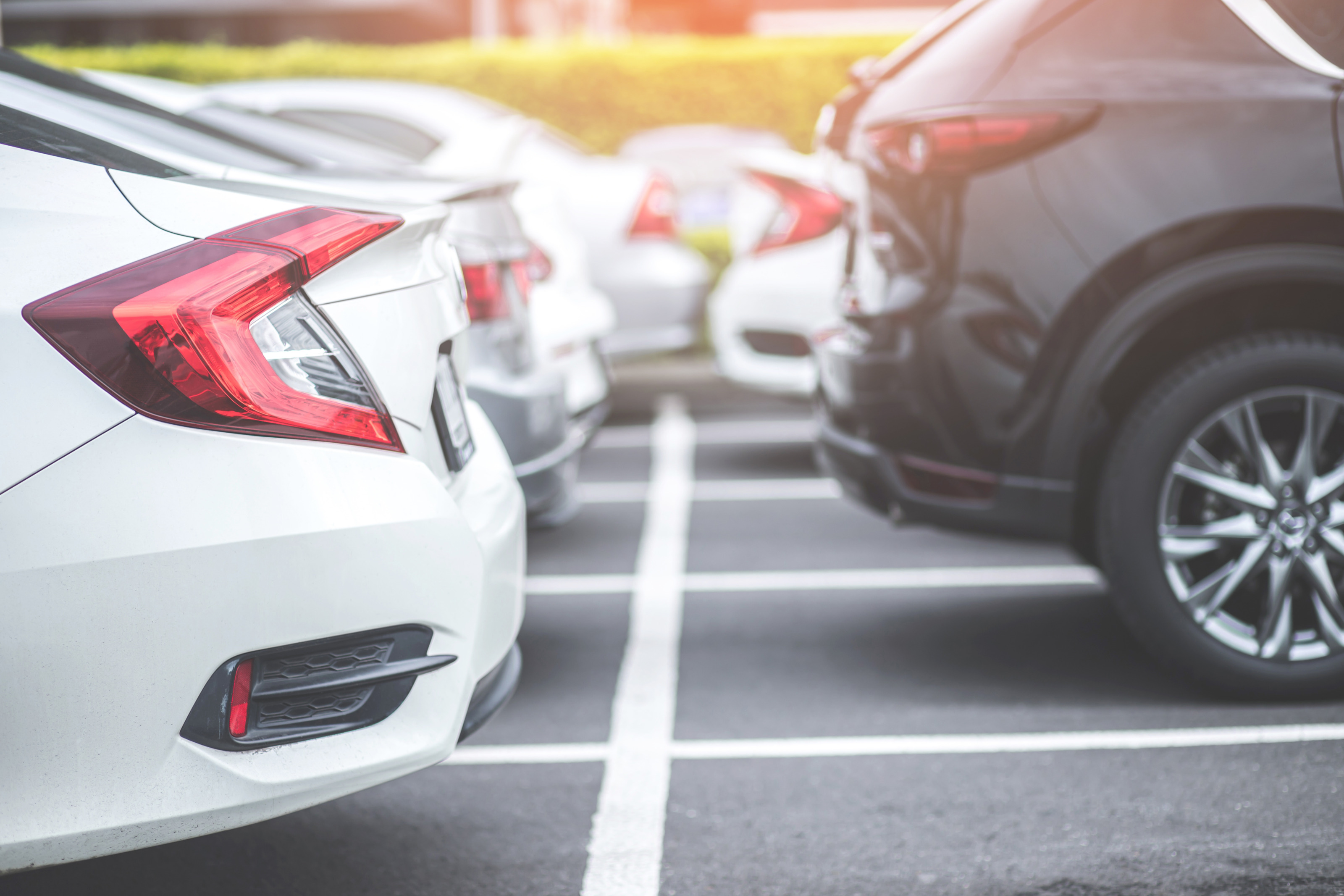 Parkende Autos auf einem Parkplatz, Fokus auf Heck, Kofferraum